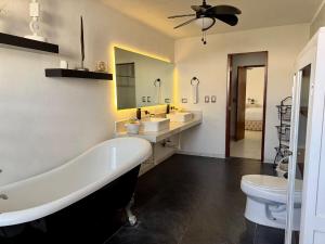 a white bathroom with a tub and a toilet at Beautiful house with a pool in Mérida +23 photos