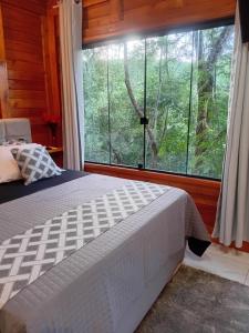 a bedroom with a bed and a large window at Cabana Zanetti in Santa Teresa +17 photos