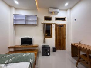 a bedroom with a bed and a wooden door at Salt & Light Labuan Bajo in Komodo Labuan Bajo Airport +12 photos