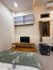 a bedroom with a bed and a window and a laptop at Salt & Light Labuan Bajo in Komodo Labuan Bajo Airport