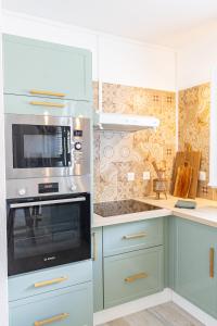 a kitchen with blue cabinets and a stove top oven at Pointe Noire in Pointe-Noire