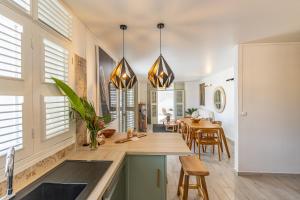 a kitchen and dining room with white walls and windows at Pointe Noire in Pointe-Noire +50 photos