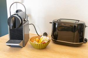 a toaster and a bowl of food next to a toaster at Pointe Noire in Pointe-Noire