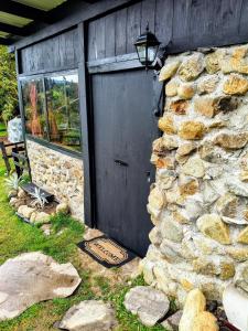 a stone building with a black door and a window at Chalet Stonehenge in Pasto