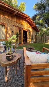 a bench and a table in front of a house at Doce inga in Cairu