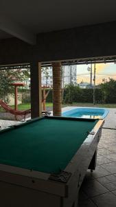 a pool table in front of a swimming pool at Econômica Joinville Hostel e Pousada in Joinville