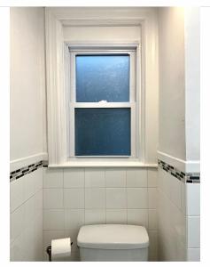 a bathroom with a toilet and a window at 7A - A Diamond in Yonkers in Yonkers +24 photos