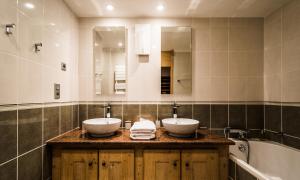a bathroom with two sinks and a bath tub at Hotel Le Portillo in Val Thorens