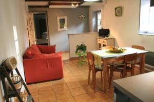 een keuken en een woonkamer met een tafel en een bank bij Moulin De Beuzidou in Saint-Urbain