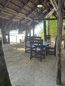 a picnic table in a hut on the beach at Hotel Restaurant Wuarao - Antiguo Club Rolling Stones in Boca Chica