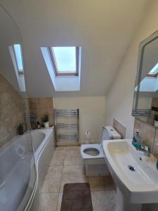 a bathroom with a sink and a toilet and a bath tub at Gracian OMB Ongar 3 Bed in Dublin