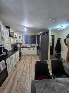 a kitchen with white cabinets and a stainless steel refrigerator at Gracian OMB Ongar 3 Bed in Dublin