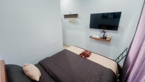 a room with a couch and a tv on a wall at Escotel Majestica in Dalung