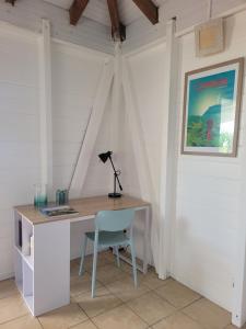a desk with a lamp and a chair in a room at Ti Kaz Robin in Trois-Rivières