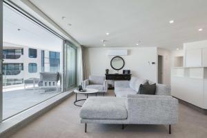 a living room with a couch and a table at Oceanside Belle in Mount Maunganui