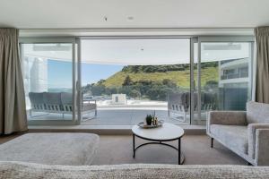 a living room with a couch and a table at Oceanside Belle in Mount Maunganui +20 photos