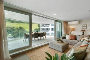 a living room with a couch and a table at Executive Oceanside Apartment in Mount Maunganui