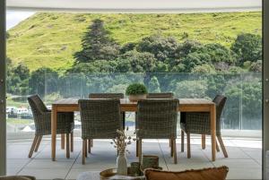 a dining room with a wooden table and chairs at Executive Oceanside Apartment in Mount Maunganui