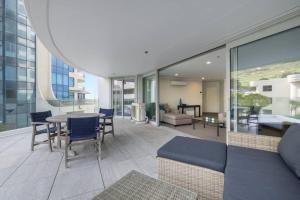 a balcony with a table and chairs on a building at Oceanside Apartment with Pool Views in Mount Maunganui +15 photos