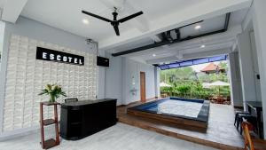 a living room with a swimming pool and a ceiling fan at Escotel Majestica in Dalung +29 photos