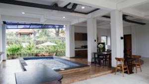 a living room with a swimming pool and a table at Escotel Majestica in Dalung