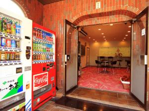 a cocacola soda machine in a store with a table at Hotel Sankyu in Tsukuba