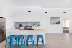 a kitchen with four blue stools in front of a counter at Casa Azul in Burrill Lake