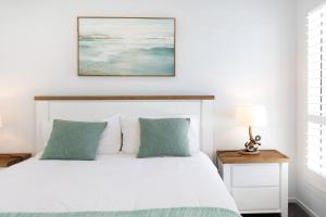 a bedroom with a white bed with green pillows at Casa Azul in Burrill Lake +18 photos