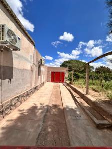 a garage with a red door on the side of a building at Casa Chule in Fiambalá