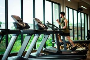 a man running on a treadmill in a gym at KINGS TOWN - Serene Bliss County in Coimbatore