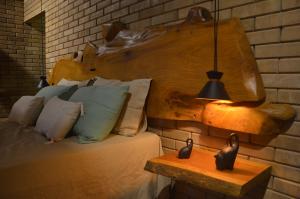 a bedroom with a bed with a wooden headboard and a lamp at Doce inga in Cairu