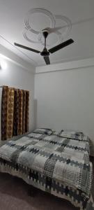a bedroom with a ceiling fan and a bed at बृजराज गेस्ट हाउस & rooms in Rīngas