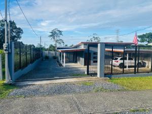 a building with a fence and a car in a parking lot at Jarkeyda House in Siquirres