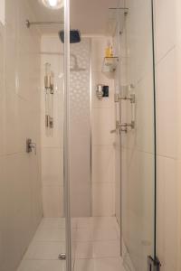 a shower with a glass door in a bathroom at Tefos room in Quito