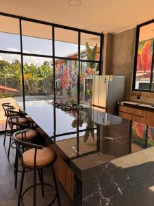 a kitchen with a counter with chairs and a large window at Hotel Campestre Alma Nativa in Calarcá