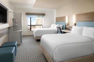 a hotel room with two beds and a flat screen tv at EVEN Hotel Rockville - Washington, DC Area by IHG in Rockville +64 photos