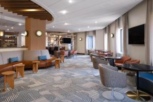 a lobby of a hotel with tables and chairs at EVEN Hotel Rockville - Washington, DC Area by IHG in Rockville