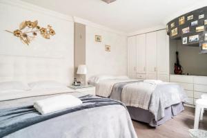 two beds in a bedroom with white walls at Luxury Home Embajada Americana in Quito