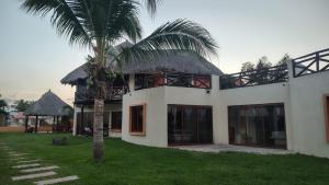 a house with a palm tree in front of it at Laguinn Hotel Acapulco in Acapulco