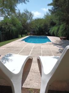 a white bench next to a swimming pool at Complejo El Tala in Villa la Bolsa