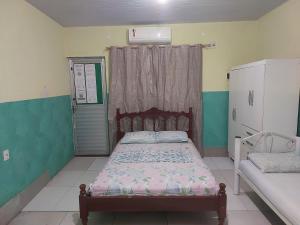 a small bedroom with a bed and a window at Casa para temporada in Belém