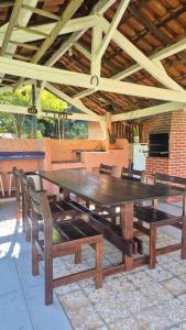 a large wooden table and chairs on a patio at Chácara Santo Antonio in Brotas
