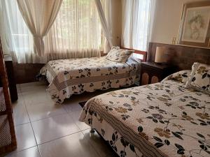 a hotel room with two beds and curtains at Miravalle Suites in Paipa +67 photos
