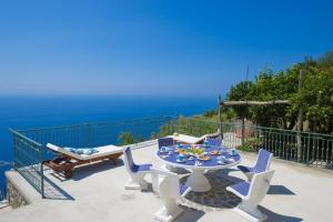 a patio with a table and chairs and the ocean at Casa Lisuccia in Furore