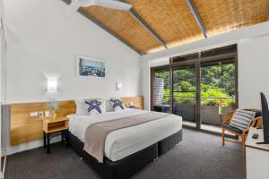 a bedroom with a bed and a desk with a computer at Nautilus Beach Resort by Charlesworth in Coffs Harbour