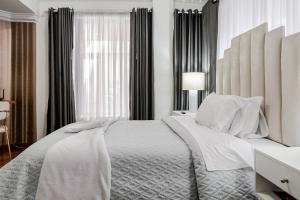 a white bedroom with a large bed and a window at Lili’s room in Quito