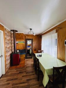 a dining room with a table and a fireplace at Ruta Pata Austral in Puerto Varas