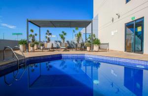 a swimming pool in front of a building at Hotel Turotel Morelia in Morelia