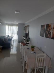 a dining room with a table and chairs and a living room at Ap 503 Ed Brisa do sol em Piratuba in Piratuba