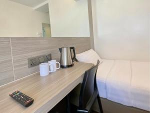 a hotel room with a desk with a bed and mugs at Red Planet Cebu in Cebu City